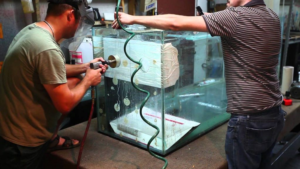 I drill a hole into a custom reef tank for a skimmer outlet.